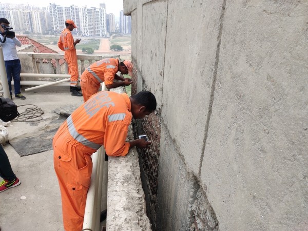 Operations were carried out to retrieve the body of a woman lying between two high-rise buildings near Amrapali Silicon City Society after residents complained about the foul smell, in Noida. NDRF