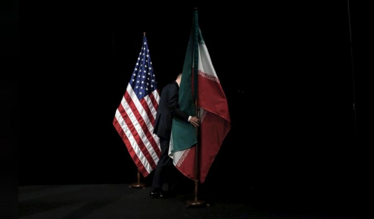 A staff member removes the Iranian flag from the stage after a group picture with foreign ministers and representatives of the U.S., Iran, China, Russia, Britain, Germany, France and the European Union during the Iran nuclear talks at the Vienna International Center in Vienna, Austria July 14, 2015. US-Iran