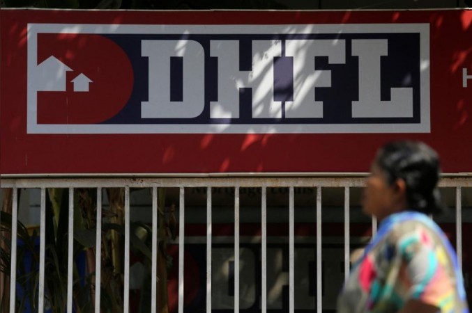 A woman walks past a signboard of Dewan Housing Finance Corporation Ltd. (DHFL) outside its office. DHFL