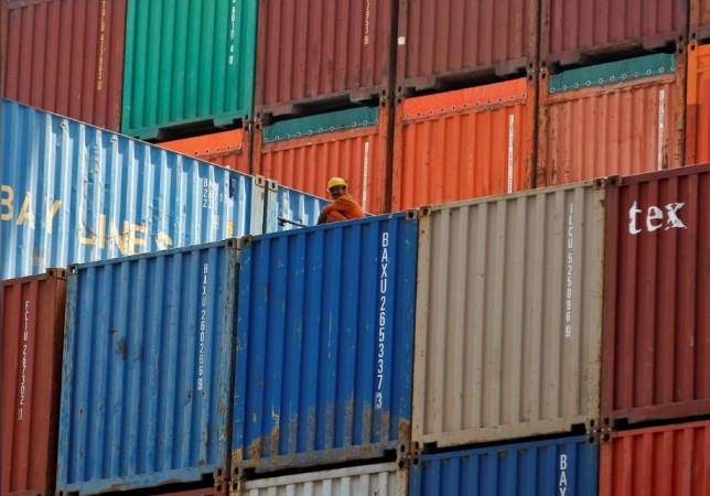 A worker sits on a ship carrying containers at Mundra Port in Gujarat April 1, 2014. Indian economy