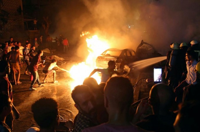 People extinguish a fire from a blast outside the National Cancer Institute, Cairo, Egypt August 4, 2019. car explosion in egypt