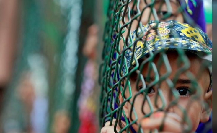 Kashmiri child looks from behind a fence at a protest site after Friday prayers during restrictions after the Indian government scrapped the special constitutional status for Kashmir, in Srinagar, August 16, 2019. Kashmiri child