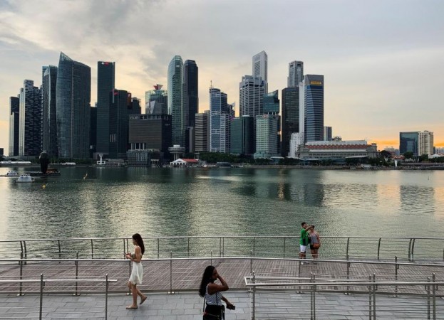 Passers-by hold their mobile phones as people take a selfie photo using a smartphone, with Singapore's central business district skyline, in Singapore, May 10, 2019. Singapore