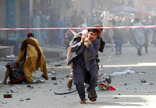 A man carries a wounded person to the hospital in Jalalabad, Afghanistan on August 19, 2019. Afganistan bomb
