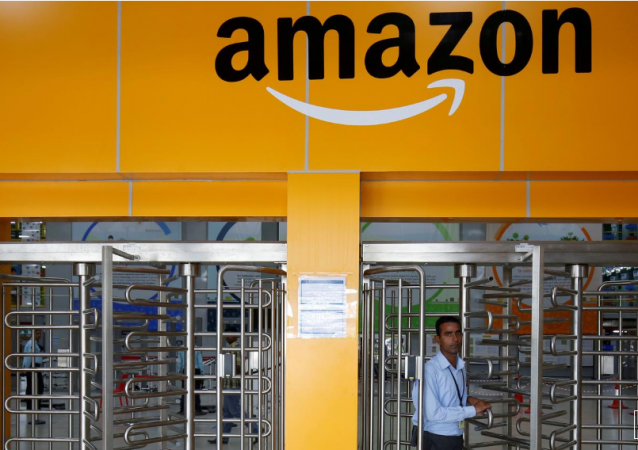 An employee of Amazon walks through a turnstile gate inside an Amazon Fulfillment Centre. amazon flipkart sale