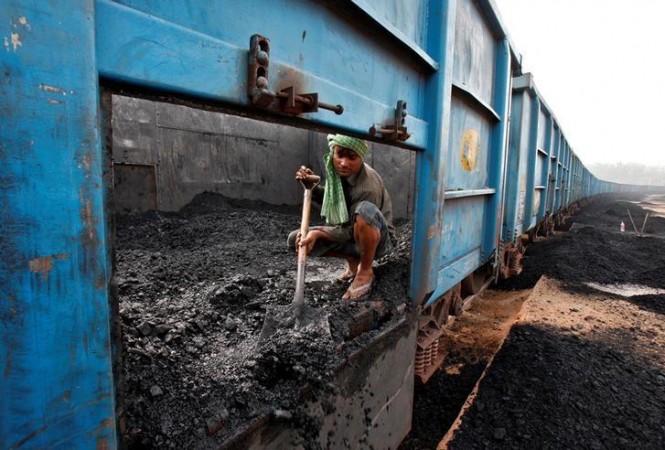 A worker unloads coal from a goods train at a railway yard in Chandigarh, India, July 8, 2014. coal India