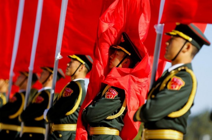 Honour guards hold red flags as they stand at attention before a welcoming ceremony for Japanese Prime Minister Shinzo Abe (not pictured) in Beijing, China October 26, 2018. Japan defence