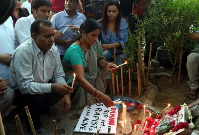 Nirbhaya's parents participate in a candlelight vigil. Nirbhaya