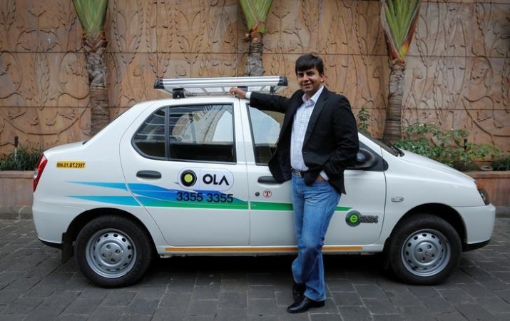 Bhavish Aggarwal, CEO and co-founder of Ola, an app-based cab service provider, poses in front of an Ola cab Ola Cabs