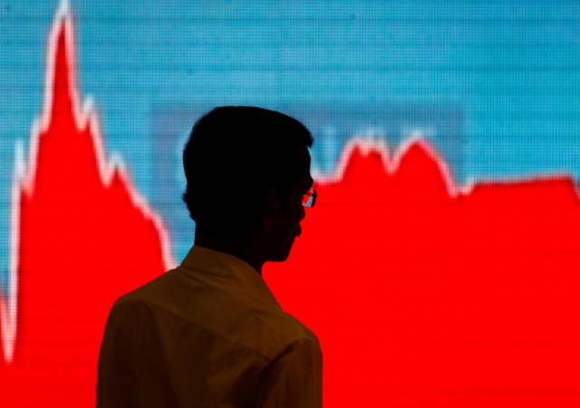A man walks past a screen displaying news of markets update inside the Bombay Stock Exchange (BSE) building in Mumbai, February 6. sensex nifty