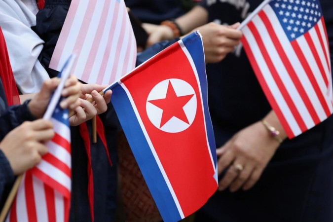 Bystanders holding North Korea and US flags. North Korea US