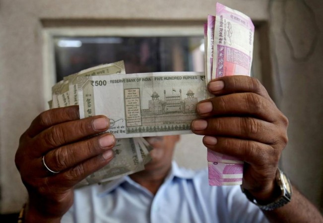 A cashier checks Indian rupee notes inside a room at a fuel station in Ahmedabad, India, September 20, 2018. Indian curreny notes