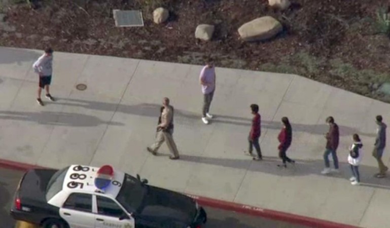 A law enforcement official leads students at the scene of a shooting at Saugus high school in Santa Clarita, California, US, November 14, 2019 in this screenshot taken from video footage courtesy of NBCLA. California school shooting