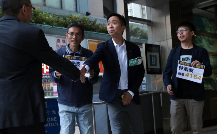 Winning candidate Kelvin Lam and activist Joshua Wong greet people and thank them for their support, outside of South Horizons Station, in Hong Kong, China, November 25, 2019, the morning after Lam won in district council elections. Hong Kong elections
