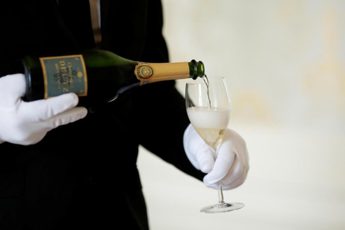 An employee serves a glass of Champagne in France. France digital tax