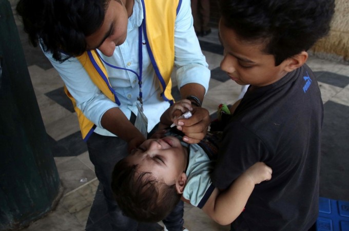 KARACHI, Oct. 24, 2017 (Xinhua) -- A health worker gives polio drops to a child on World Polio Day in southern Pakistani port city of Karachi on Oct. 24, 2017. polio