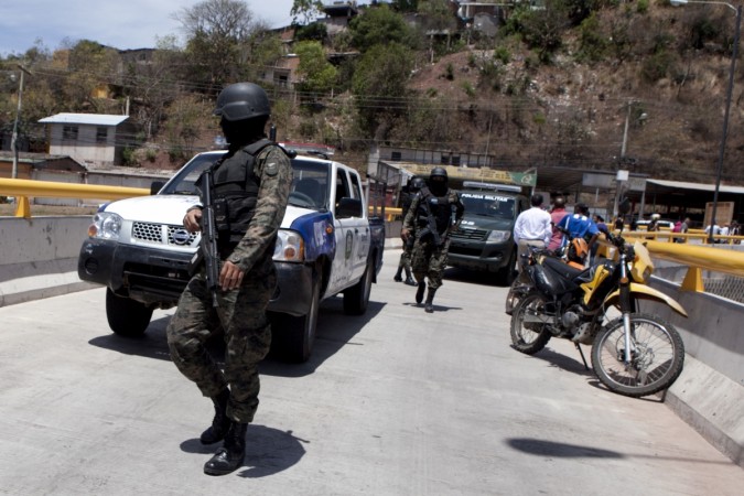 Honduran authorities inspect the site of the homicide of three women, in Tegucigalpa, Honduras. Honduran authorities
