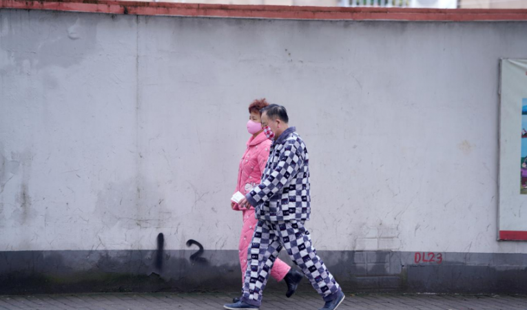 Residents wearing face masks and pyjamas are seen on a street in Shanghai, China, as the country is hit by an outbreak of the novel coronavirus, February 14, 2020. china Coronavirus