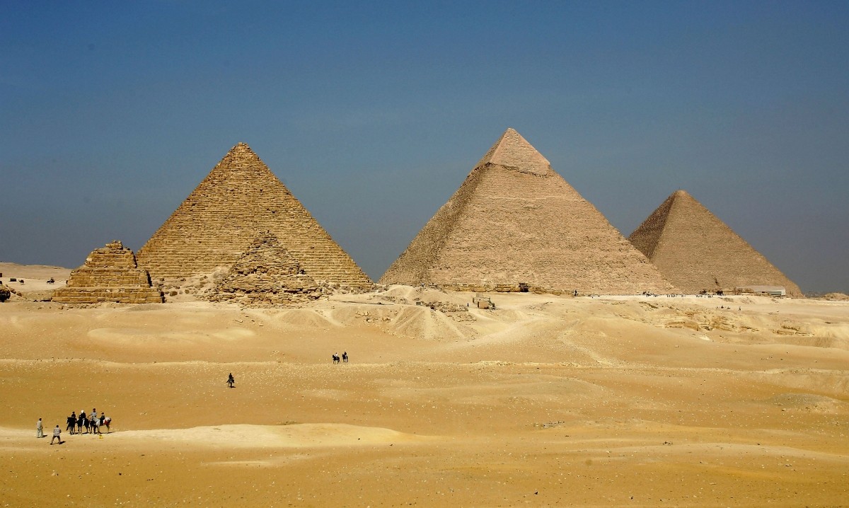 The three large pyramids of Menkaure (L), Khafre (C) and Khufu loom over the horizon November 13, 2004 at Giza, just outside Cairo, Egypt. Egypt