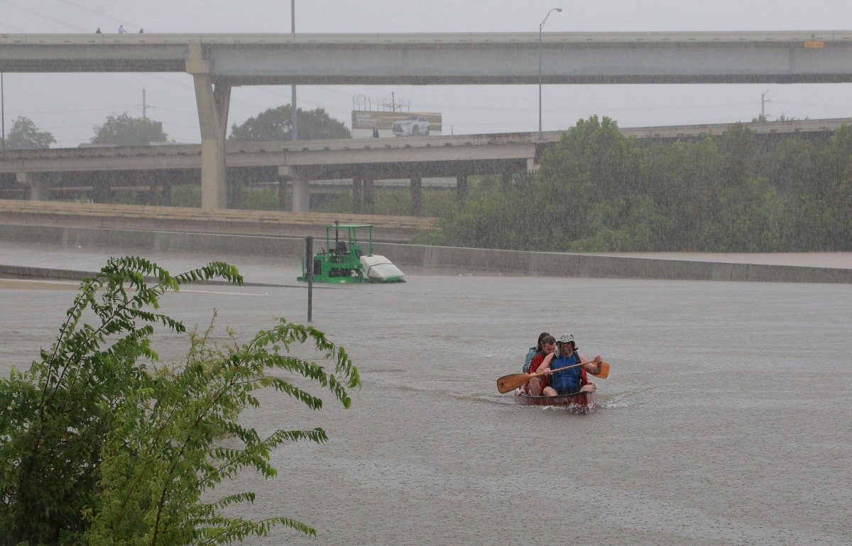 Area residents use a kayak to rescue motorists stranded on Interstate highway 45 which is submerged from the effects of Hurricane Harvey seen during widespread flooding in Houston Houston floods