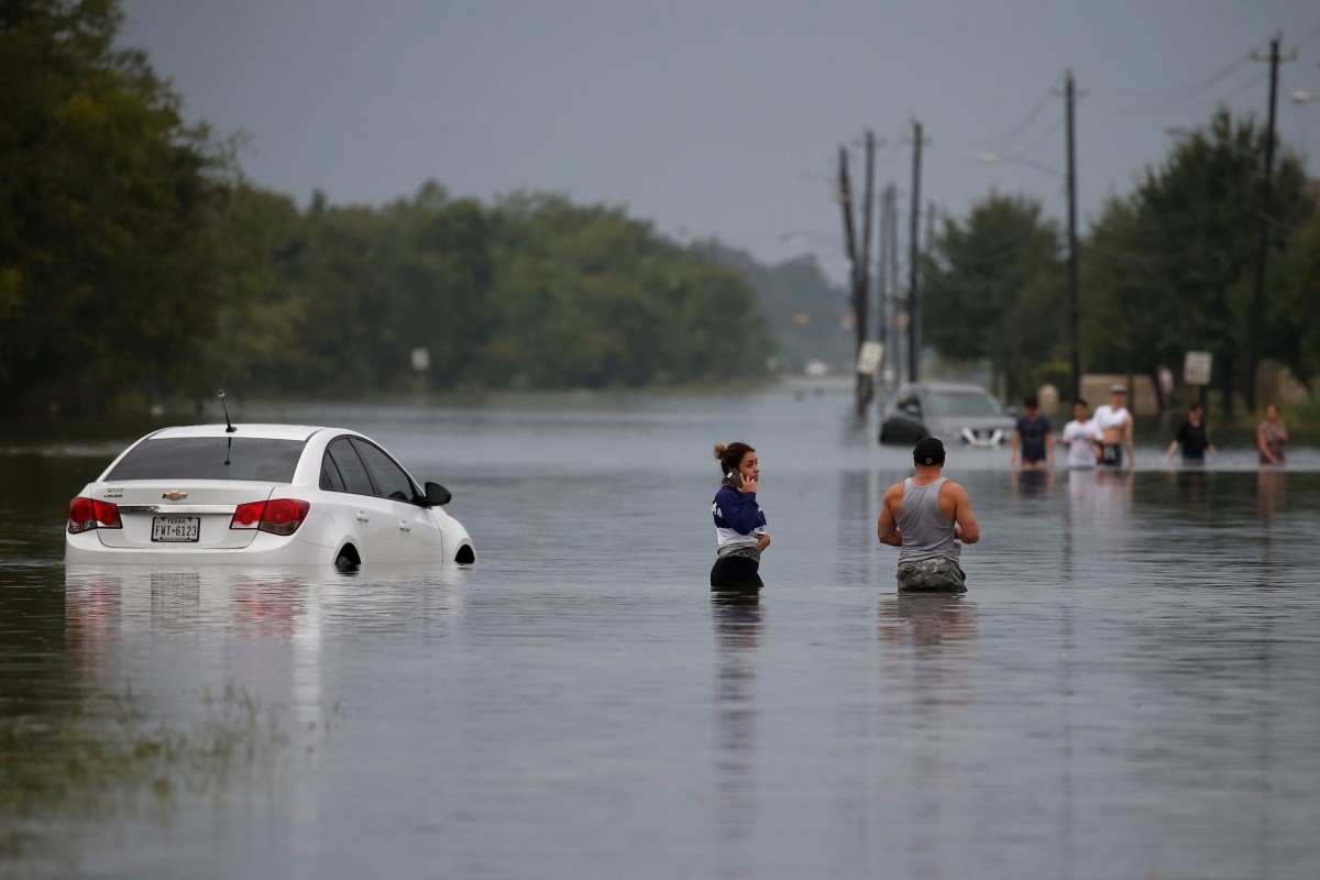 Residents wade through flood waters from Tropical Storm Harvey in Houston, Texas, U.S. Tropical storm Harvey