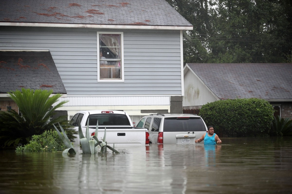 People wait to be rescued from their flooded homes after the area was inundated with flooding from Hurricane Harvey on August 28, 2017 in Houston, Texas. Houston floods