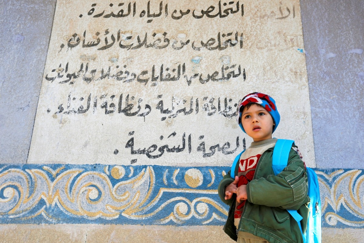 A child waits for his father at a school in Mosul. A full return to normalcy will not be easy for children, who bear the scars of living in the Islamic State's de facto capital in Iraq. After the ISIS defeat by US-led special forces, children return to school in east Mosul, Iraq