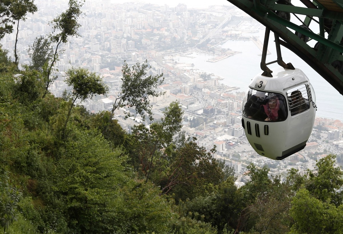 Tourists sit in a cable car from Harisa into Jounieh in northern Beirut April 18, 2013.A new Lebanese government's best hope of rebooting its battered economy may lie in efforts to persuade wealthy Gulf Arab tourists to return after a boycott last year, but it is a gargantuan task. Beirut