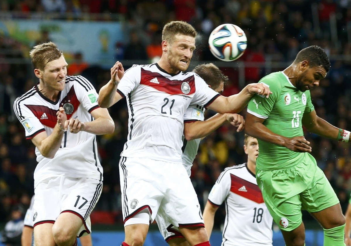 Germany's Mertesacker and Mustafi jump for the ball with Algeria's Soudani during their 2014 World Cup round of 16 game at the Beira Rio stadium in Porto Alegre Germany vs Algeria