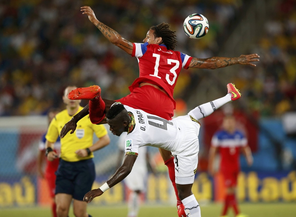 Jermaine Jones of the U.S. jumps for the ball against Ghana's Daniel Opare during their 2014 World Cup Group G soccer match at the Dunas arena in Natal Ghana vs USA