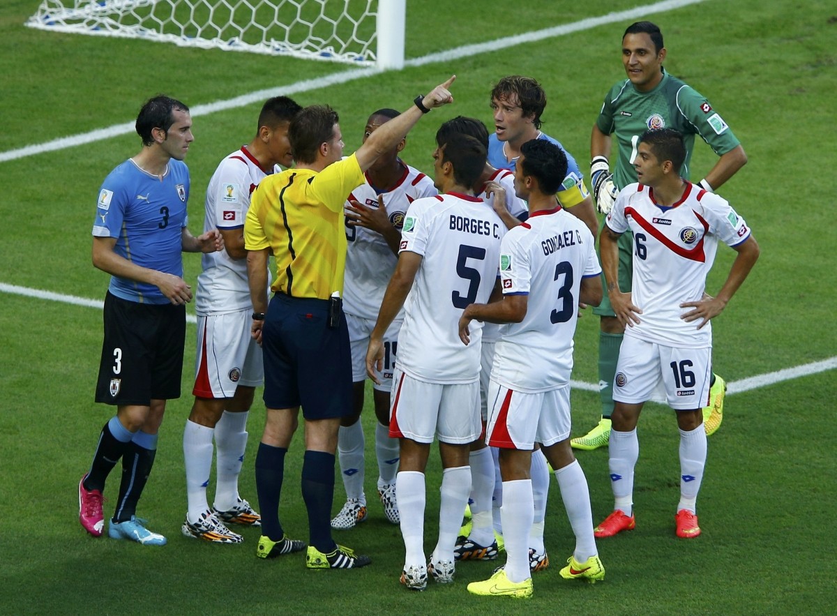 Costa Rica's national soccer players argue with referee Brych after he issued the team a penalty Uruguay v Costa Rica