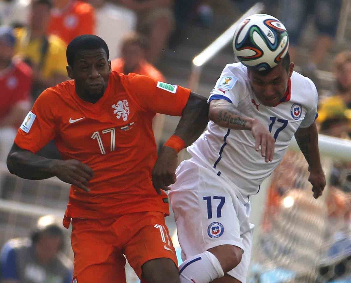Chile's Medel heads the ball next to Lens of the Netherlands during their 2014 World Cup Group B match at the Corinthians arena in Sao Paulo Netherlands v Chile
