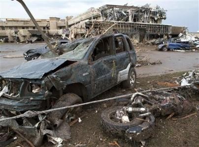 A destroyed motorcycle lies next to a crushed vehicle after a huge tornado struck Moore, Oklahoma, near Oklahoma City, May 20, 2013. (REUTERS/Richard Rowe)