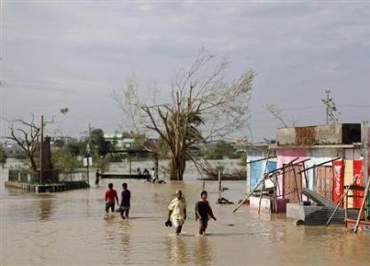 Residents wade through a flooded road after Cyclone Phailin hit Gopalpur in Ganjam district in the eastern Indian state of Odisha October 13, 2013.