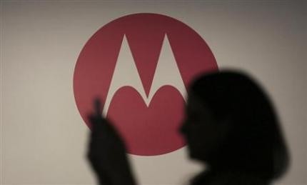 A woman takes a picture in front of a Motorola logo before the worldwide presentation of the Moto G mobile phone in Sao Paulo November 13, 2013. Motorola