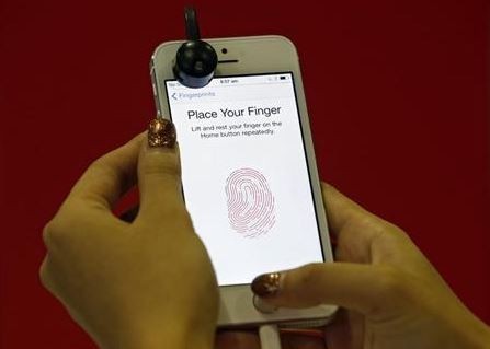 A promoter demonstrates the fingerprint scanner feature of the newly launched Apple iPhone 5S in Singapore September 20, 2013 Apple iPhone 5S Fingerprint 'Touch ID' Security Feature