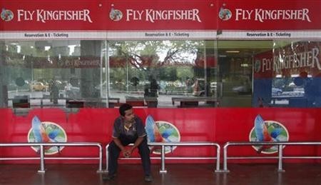 An airlines staff member sits in front of a closed Kingfisher Airlines ticketing counter at the airport in Kolkata October 3, 2012.
