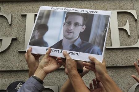 Protesters supporting Edward Snowden, a contractor at the National Security Agency (NSA), hold a photo of Snowden during a demonstration outside the U.S. Consulate in Hong Kong June 13, 2013.