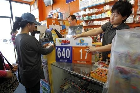 Store owner Jean Shin places a sign with the updated jackpot at the Town & Country news stand in Los Angeles, California March 30, 2012.