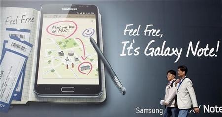 Visitors walk past a Samsung Galaxy Note advertisement board Samsung Smart Device