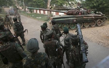 A tank from the Indian army moves past soldiers during a search operation after a gun battle at an army camp in Mesar in Samba district on September 26, 2013. The defence establishment is raising integrated battle groups (IBG) with the deep-strike capability and planning to deploy them in Jammu, Punjab, and Rajasthan. A tank from the Indian army moves past soldiers during a search operation after a gun battle at an army camp in Mesar in Samba district September 26, 2013.