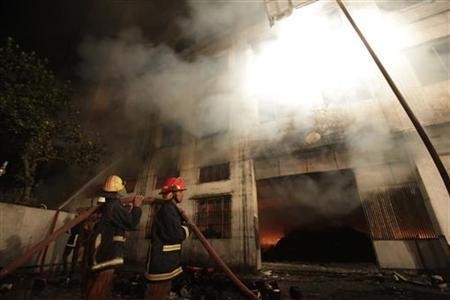 Firefighters try to control a fire in a garment factory in Savar, on the outskirts of Dhaka November 24, 2012. REUTERS/Andrew Biraj Fire in Bangladesh garment factory