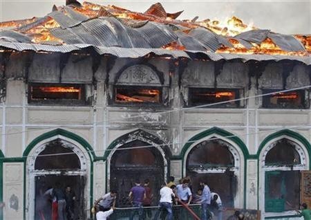 Local residents try to extinguish a fire that broke out at a Sufi shrine in Srinagar June 25, 2012. Local residents try to extinguish a fire that broke out at a Sufi shrine in Srinagar June 25, 2012. REUTERS/Danish Ismail