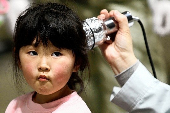 A young girl receives a radiation scan in Fukushima prefecture