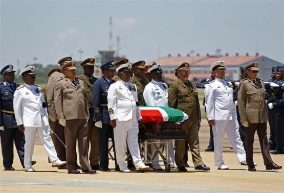 The coffin of former South African President Nelson Mandela is escorted aboard a military cargo plane after a send-off ceremony at Waterkloof Air Force base in Pretoria December 14, 2013 Mandela's Coffin