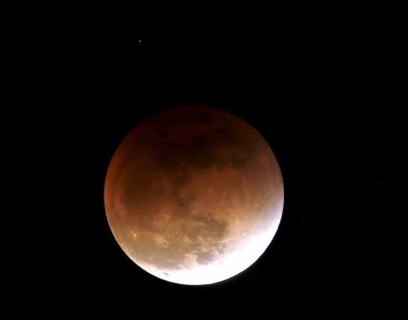 The moon, appearing in a dim red colour, is covered by the Earth's shadow during a total lunar eclipse in Bogota, Colombia September 27, 2015. Sky-watchers around the world were treated when the shadow of Earth cast a reddish glow on the moon, the result of rare combination of an eclipse with the closest full moon of the year. The total Blood Moon