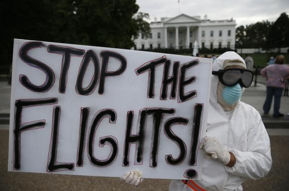 Protestor Jeff Hulbert of Annapolis, Maryland holds a sign reading ''Stop the Flights'' as he demonstrates in favor of a travel ban to stop the spread of the Ebola virus, in front of the White House in Washington.