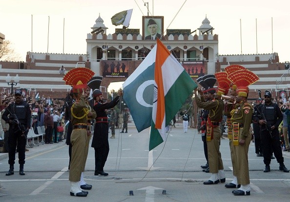 Pakistani Rangers BSF personnel fold their national flags as they perform during the daily beating of the retreat ceremony on the India-Pakistan Border india pakistan