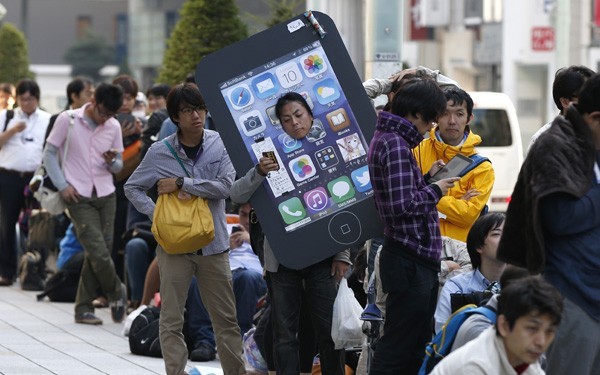 An iPhone fan waits outside an Apple Store to purchase Apple's new iPhone at Tokyo's Ginza shopping district (Reuters) Apple iPhone launch