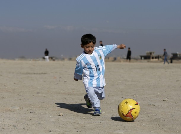 Murtaza Ahmadi, an Afghan Lionel Messi fan, wears a shirt signed by Barcelona star Lionel Messi as he plays football at the open area in Kabul, Afghanistan February 26, 2016. messi fan
